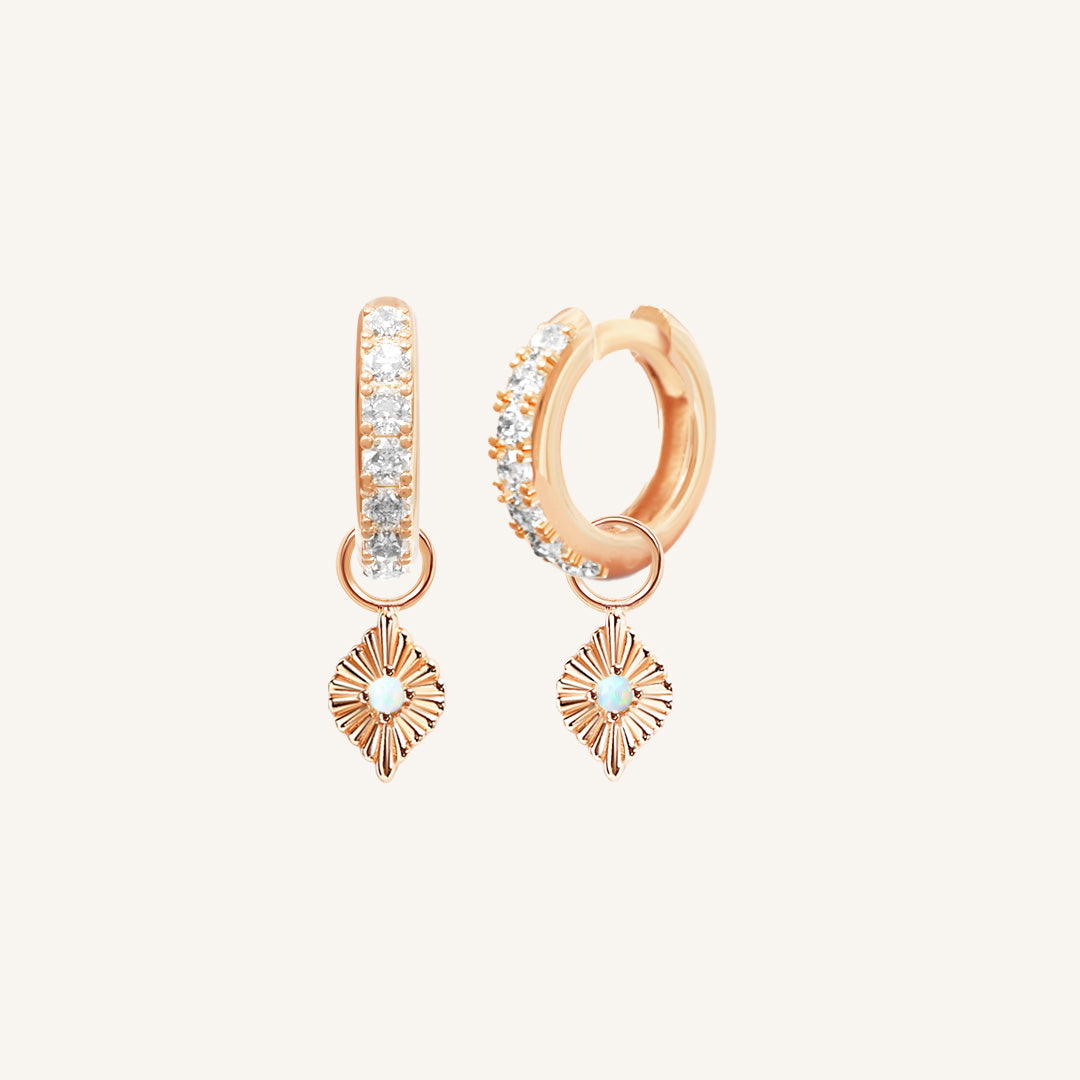 A pair of rose hoop earrings with cubic zirconia and diamond shaped hoop charms featuring a faux opal