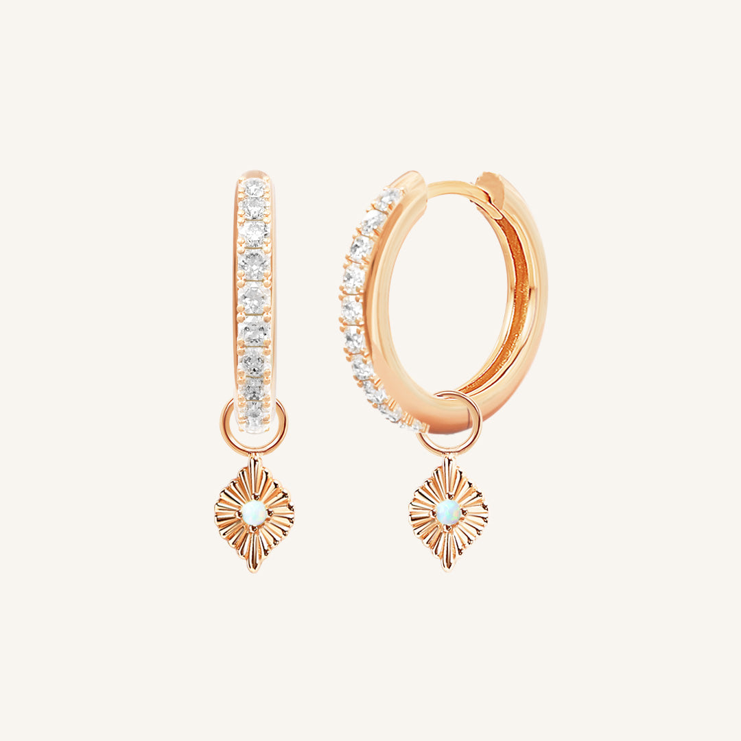 A pair of rose hoop earrings with cubic zirconia and diamond shaped hoop charms featuring a faux opal