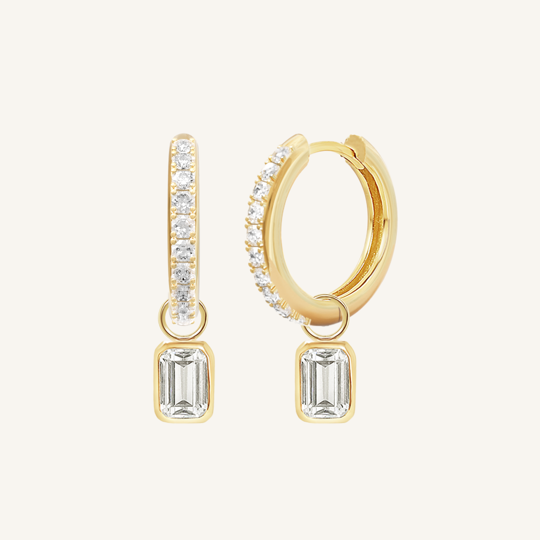 A pair of gold-tone radiant crystal hoop earrings with charm drops.