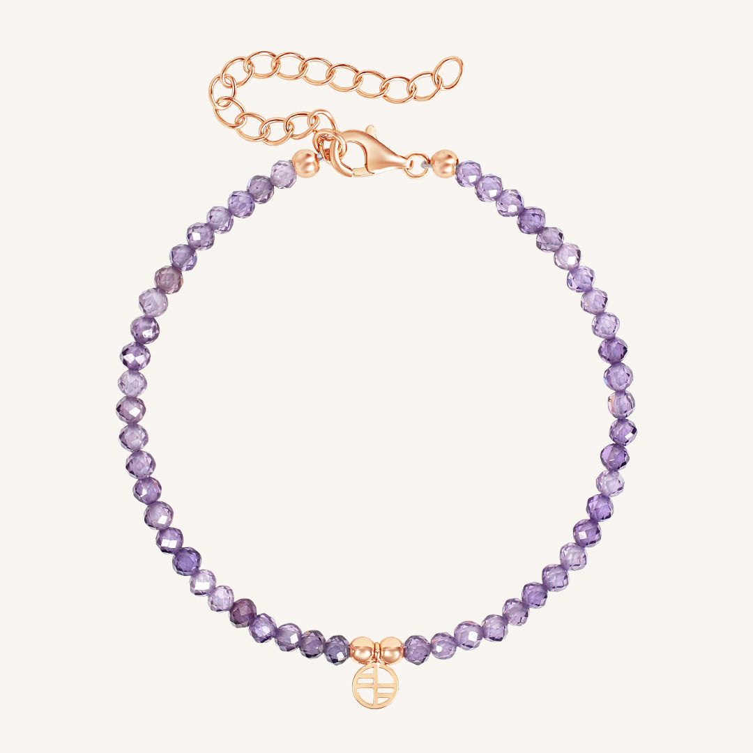 Purple beaded bracelet with a gold clasp on a white background