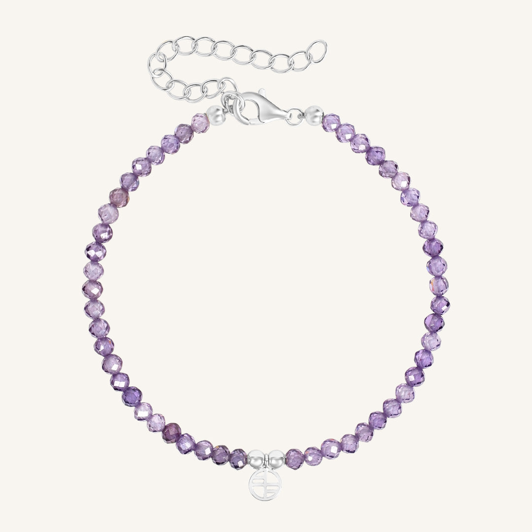 Purple beaded bracelet with silver clasp on a white background