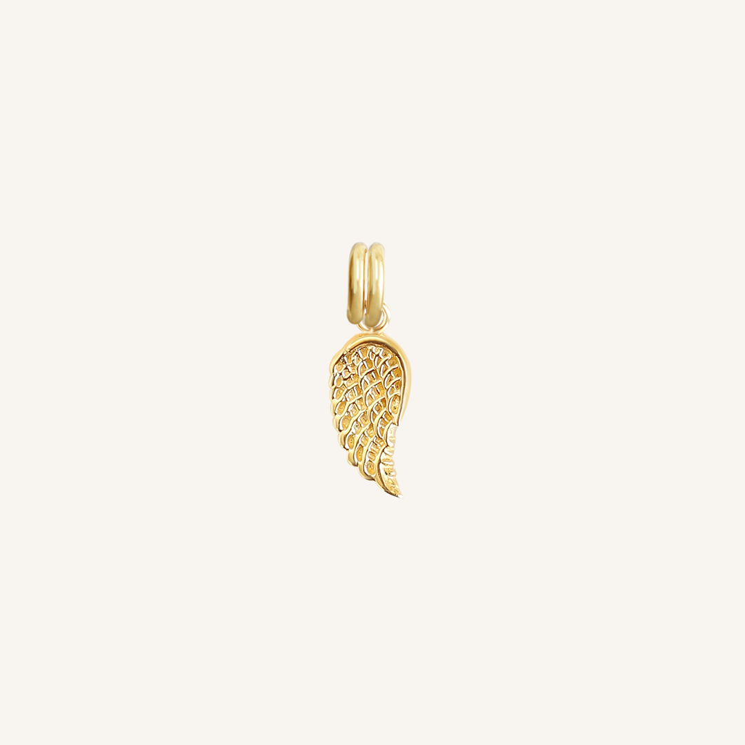 A gold-coloured angel wing charm with intricate details