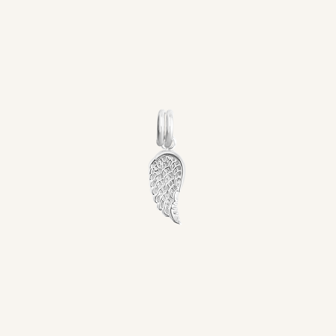 A silver-coloured angel wing charm with intricate details