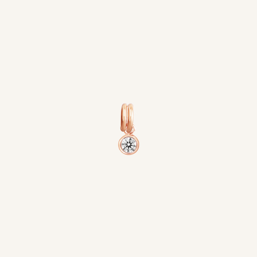 Round rose gold charm with bezel-set white cubic zirconia representing the April birthstone