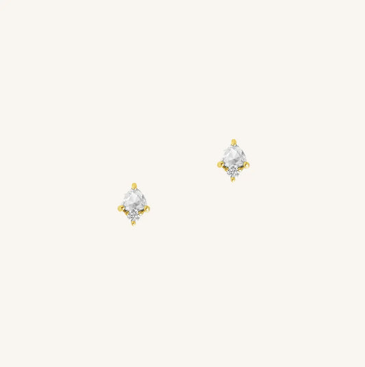 A gold pair of stud earrings featuring a white cubic zirconia, representing April.