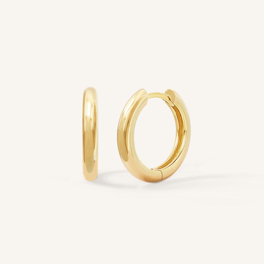 A pair of gold-colored hoop earrings on a white background