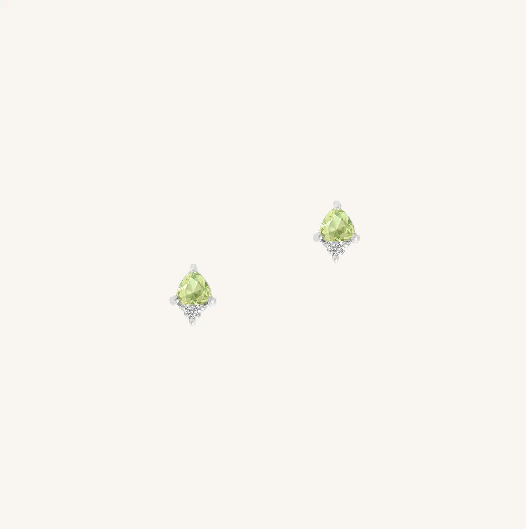 A silver pair of stud earrings featuring a green cubic zirconia, representing August.
