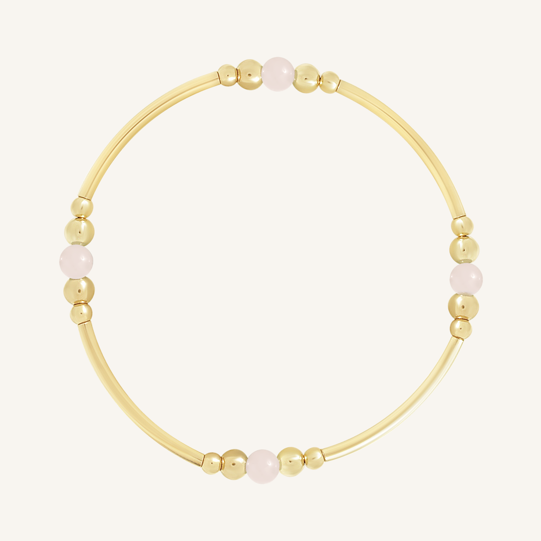 A gold-tone beaded bracelet with rose quartz stones