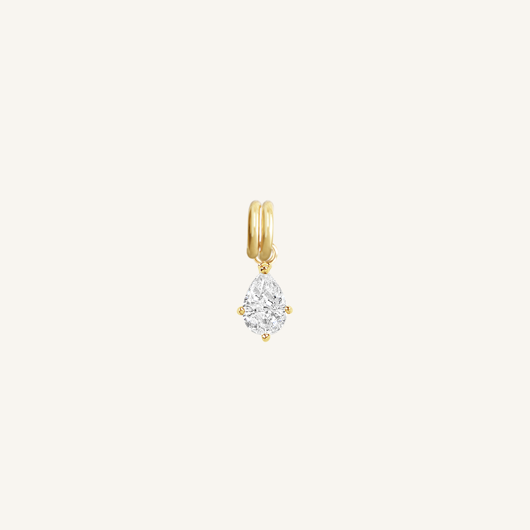 A teardrop-shaped cubic zirconia charm with a gold metal tone