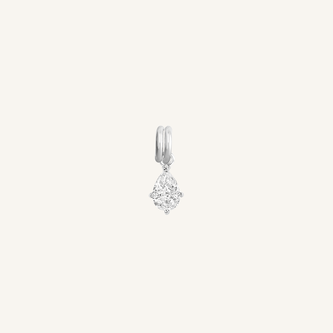 A teardrop-shaped cubic zirconia charm with a silver metal tone
