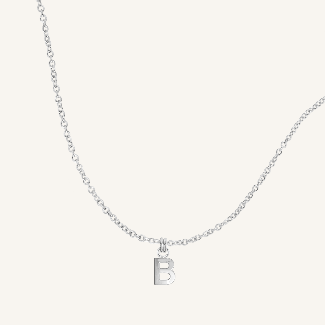 Silver necklace with a 'B' pendant on a light gray background