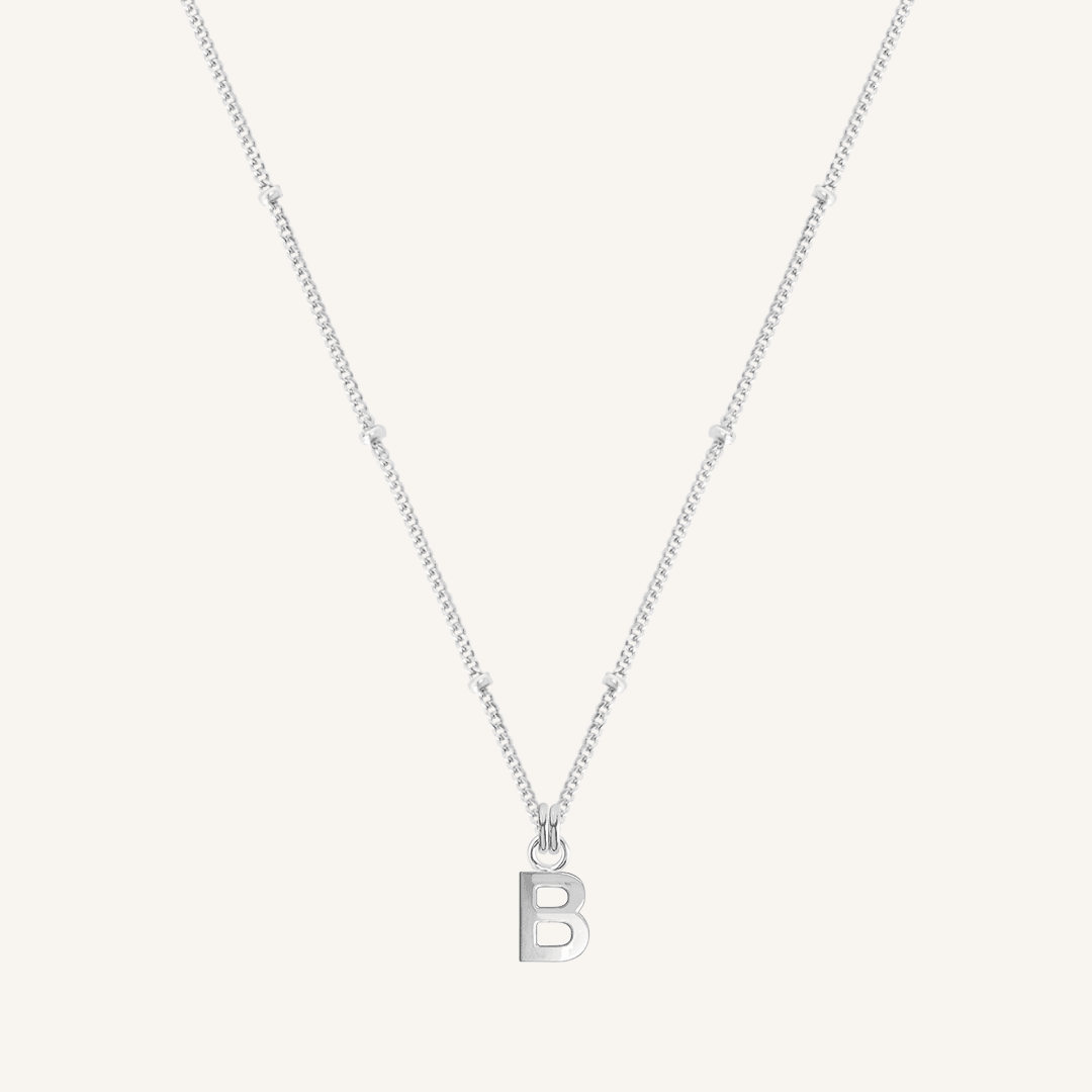 Silver necklace with a 'B' pendant on a light gray background