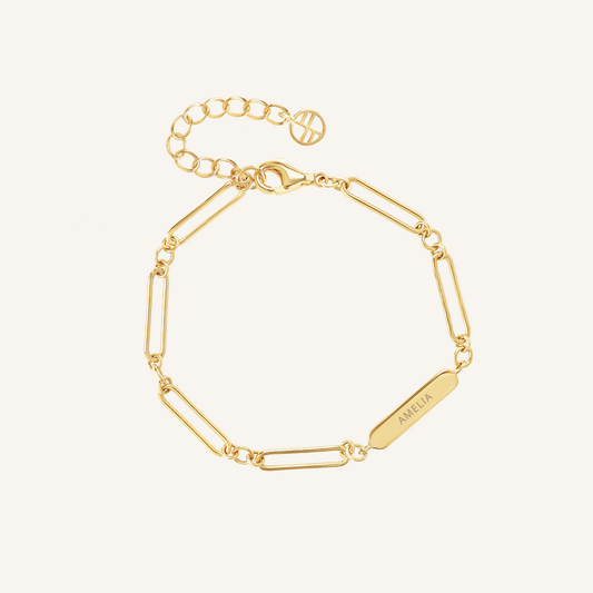 A gold-tone bracelet with a chain design and an engraving bar, displayed against a white background, made for children