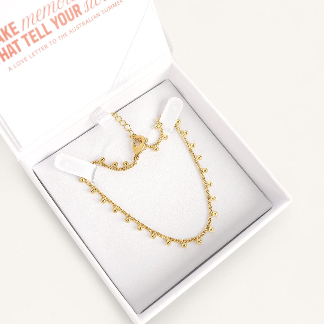 Gold anklet, displayed in white box