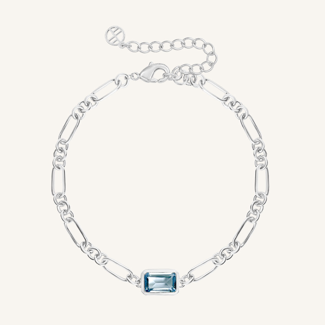 Silver bracelet with a blue gemstone on a white background