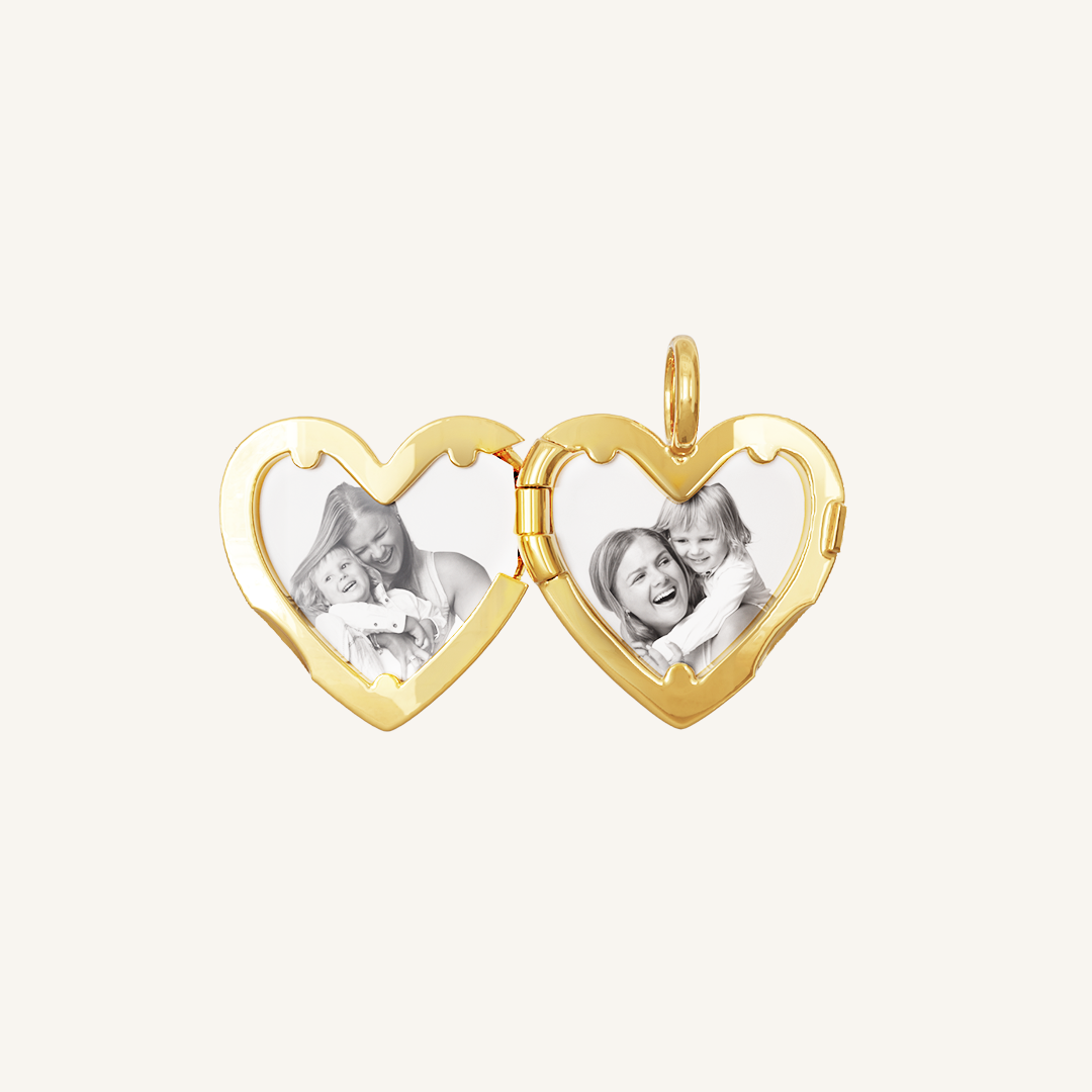 A gold heart-shaped photo locket with two images inside