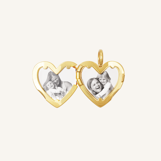 A gold heart-shaped photo locket with two images inside