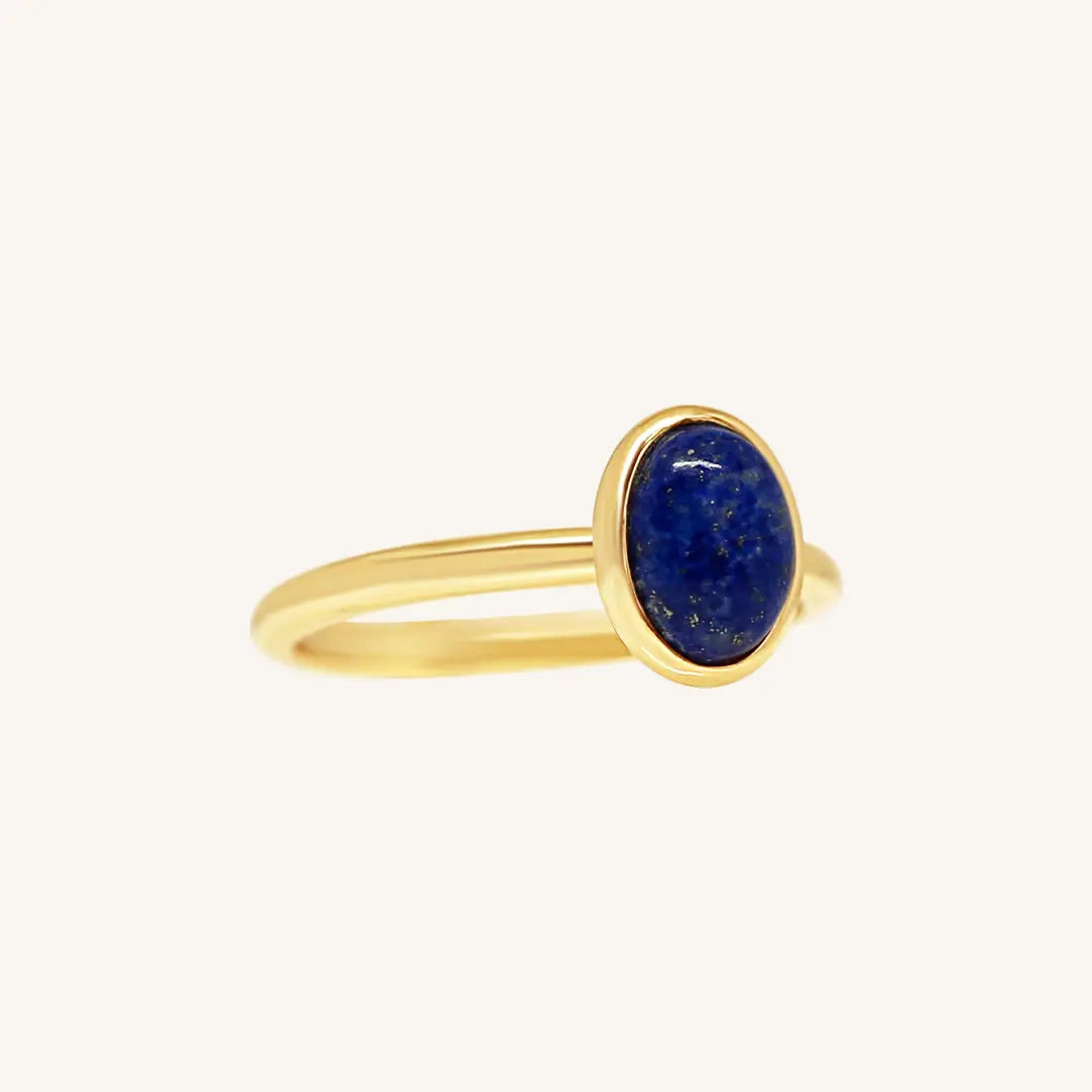 A gold ring with a deep-blue lapis stone set in a thinner band.