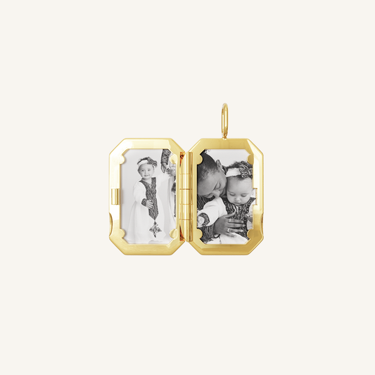 A gold bevel photo locket opened to display photographs inside.