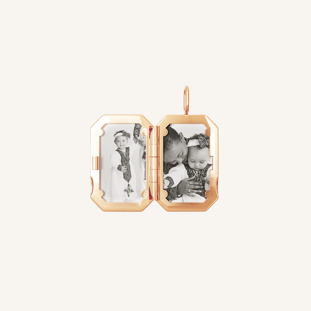 A rose gold bevel photo locket opened to display photographs inside.