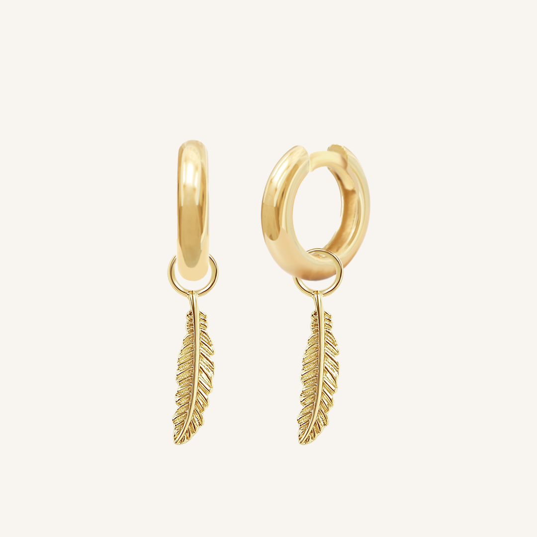 A set of two gold hoop charms with a feather design, on gold hoops
