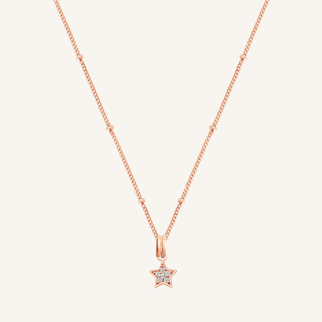 A rose gold necklace featuring a star-shaped charm pendant with cubic zirconias in the centre.