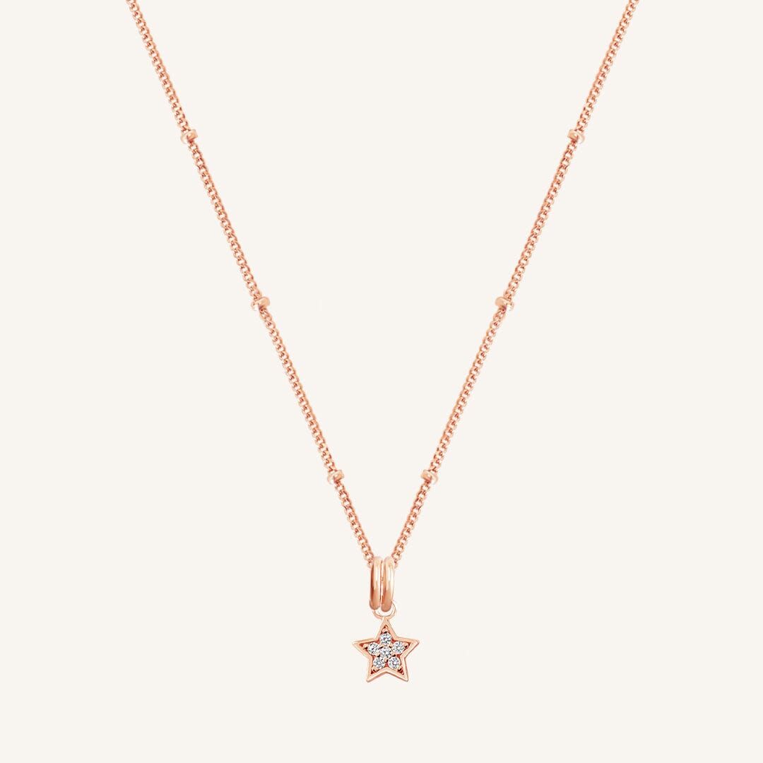 A rose gold necklace featuring a star-shaped charm pendant with cubic zirconias in the centre.