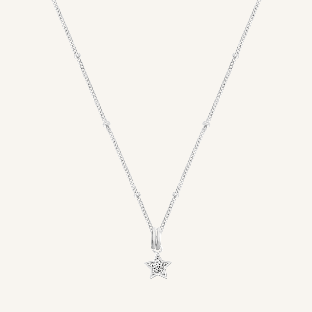 A silver necklace featuring a star-shaped charm pendant with cubic zirconias in the centre.