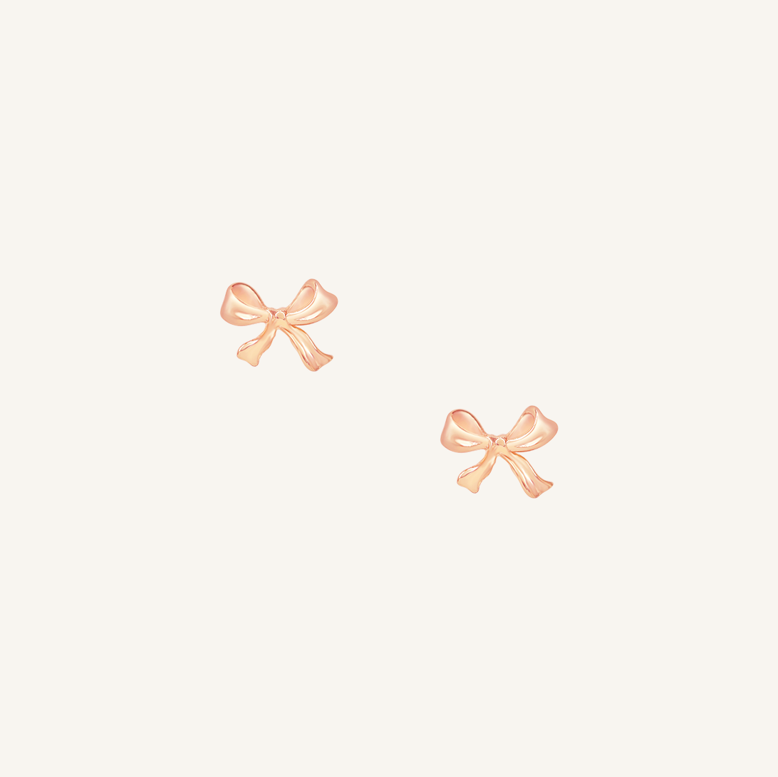A pair of rose bow stud earrings on a white background