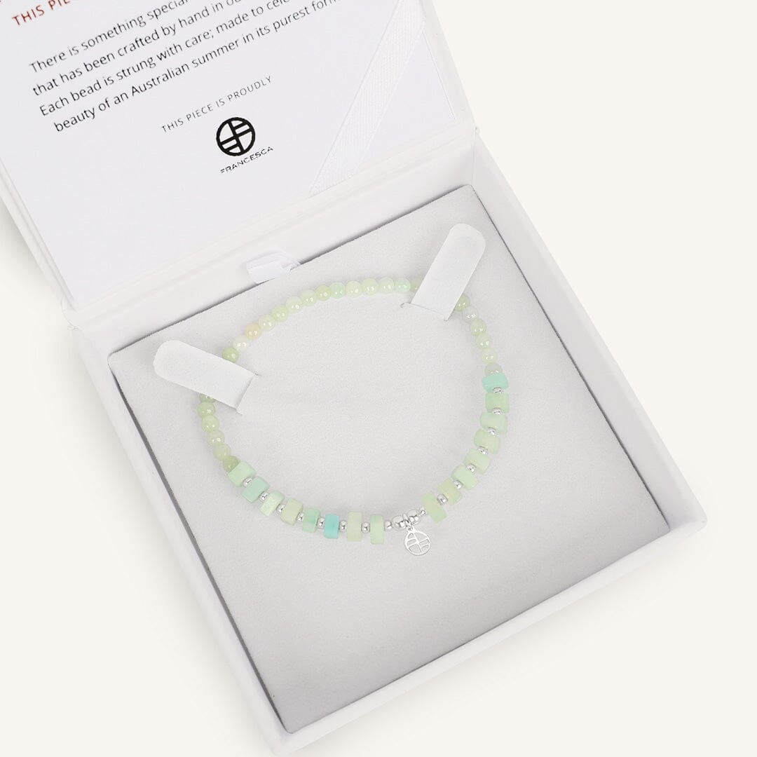 Bracelet with light green beads and gold accents, in white box