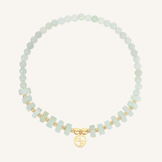 Bracelet with light green beads and gold accents on a white background