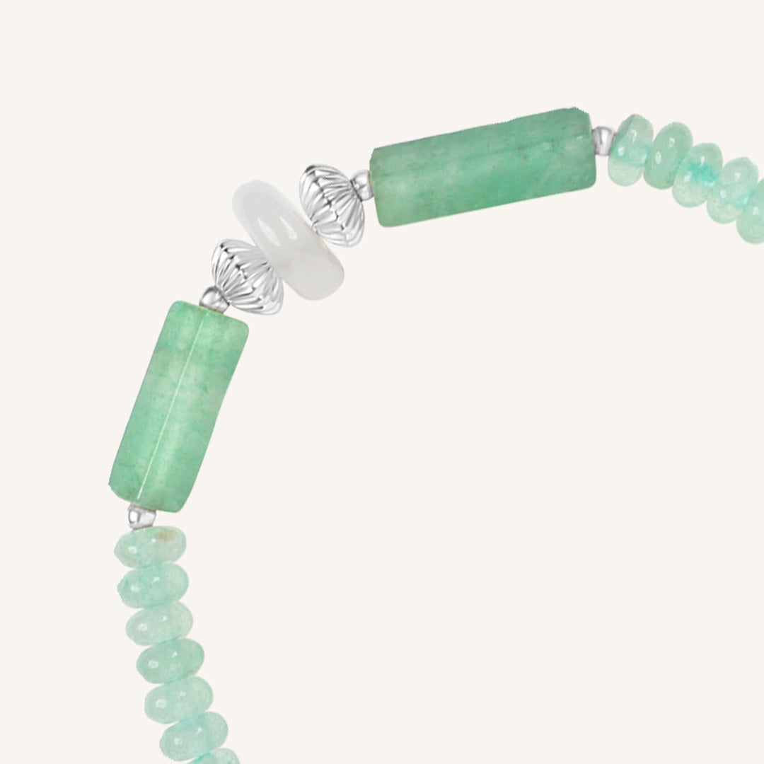 Green beaded bracelet with silver clasp on a white background