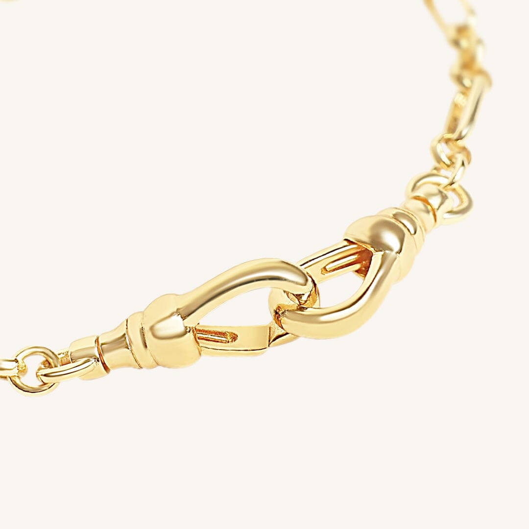 Gold chain bracelet on a light beige background