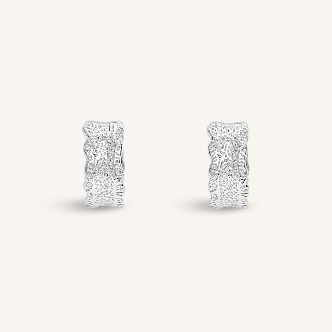 Pair of silver hoop earrings on a white background
