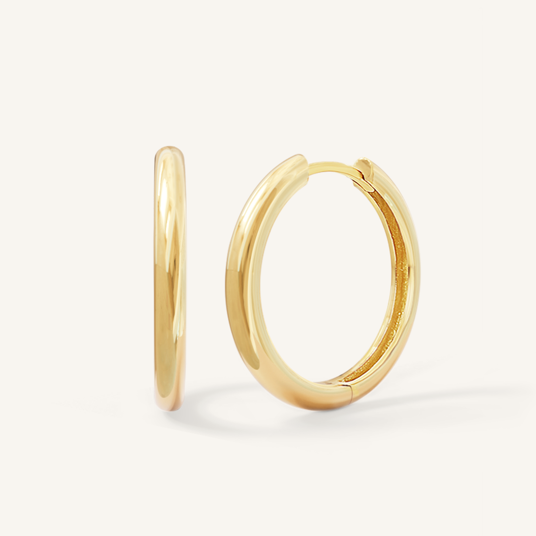 A pair of gold-tone hoop earrings on a white background