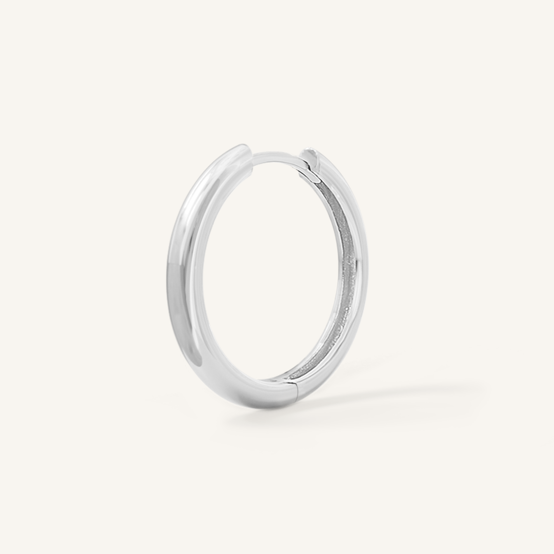 A silver hoop earring on a white background