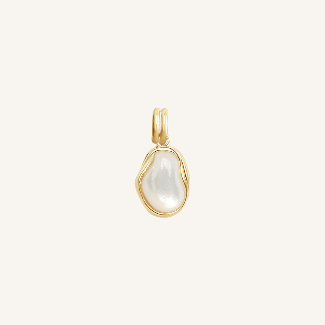 Gold pendant with a white stone on a light beige background