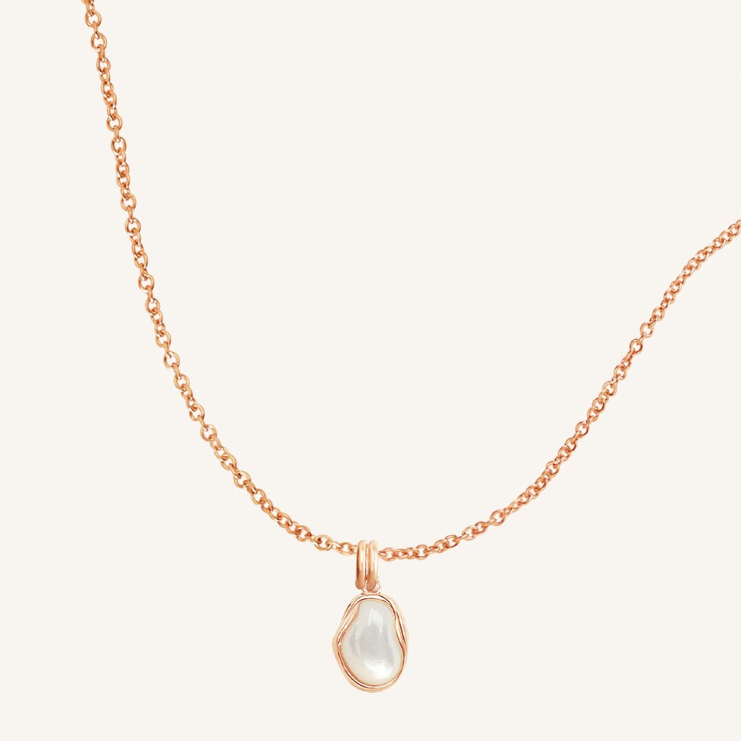 Necklace with a teardrop-shaped pendant on a light beige background