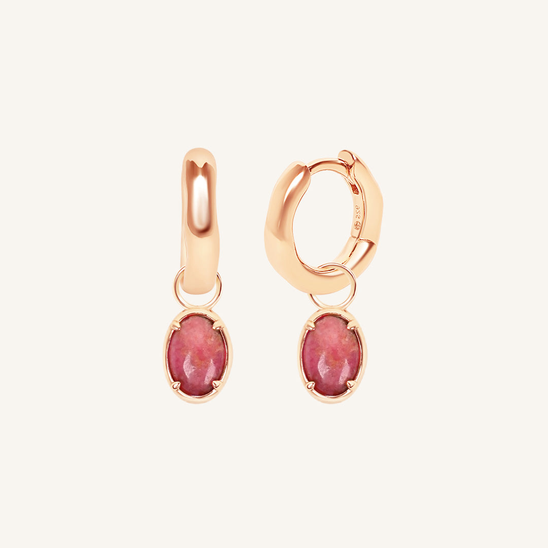 Rose gold hoop earrings with pink gemstones on a white background