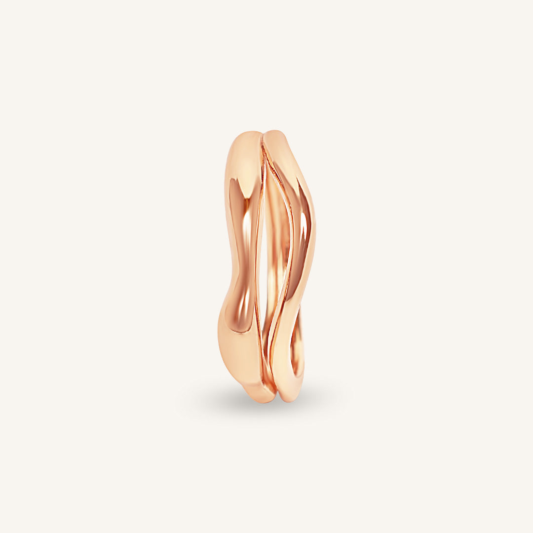 Rose gold ring with a wavy design on a light beige background