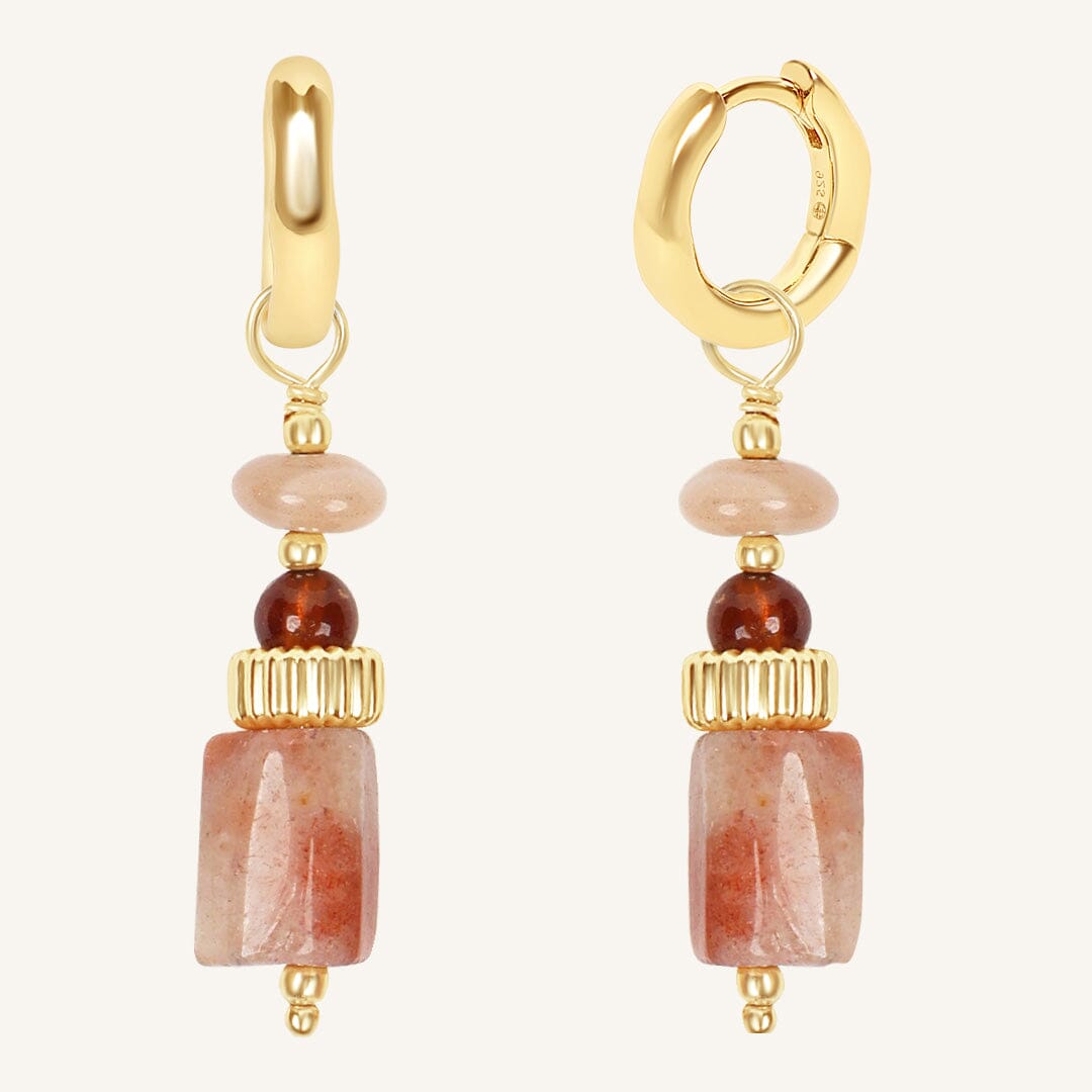 Gold hoop earrings with stone beads on a white background