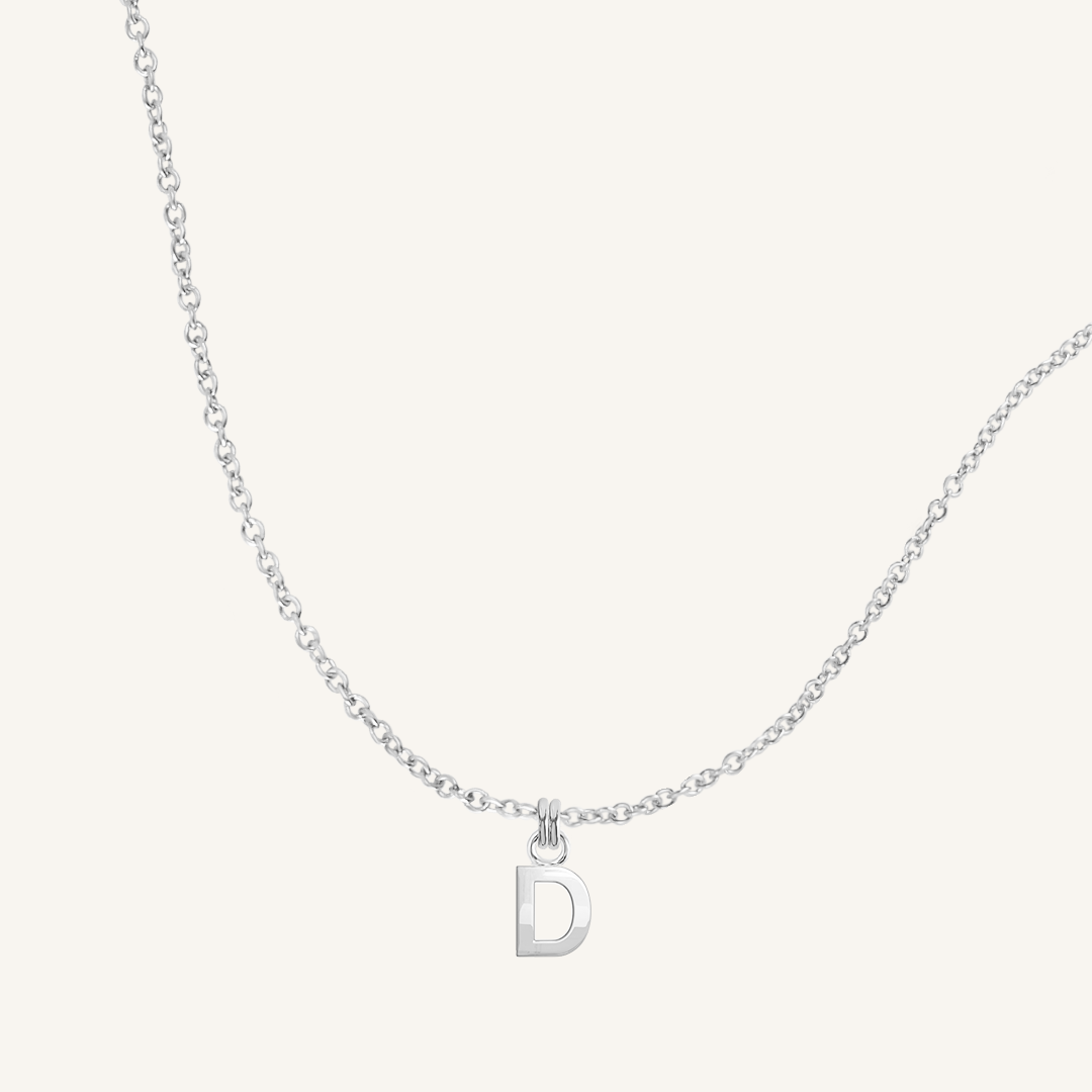 Silver necklace with a 'D' pendant on a light gray background