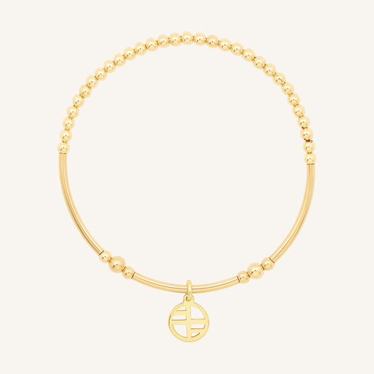 A gold-tone charm bracelet with a beaded design and a charm pendant in the center.