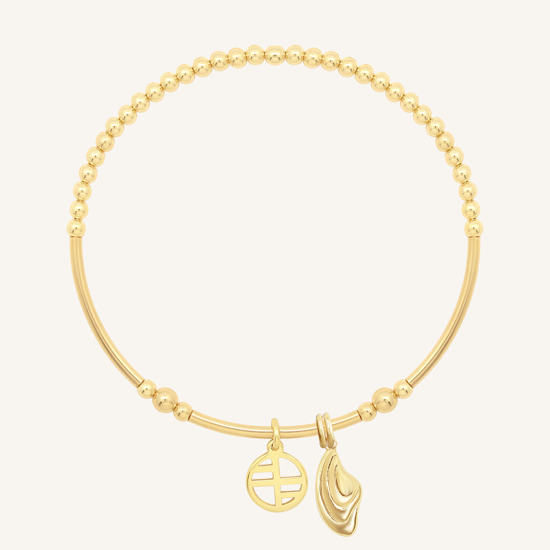 Gold bracelet with two charms on a white background