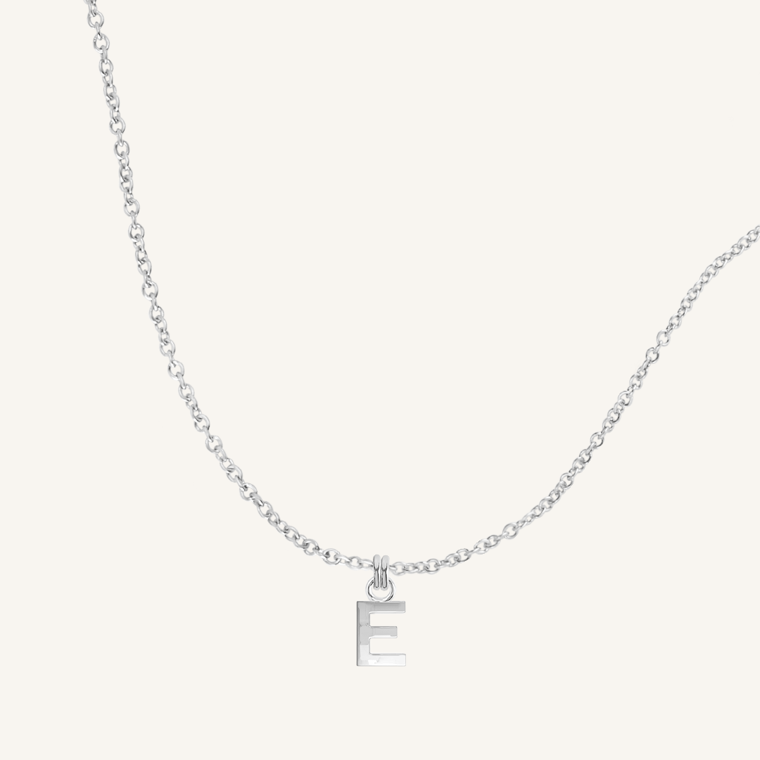 Silver necklace with a 'E' pendant on a light gray background