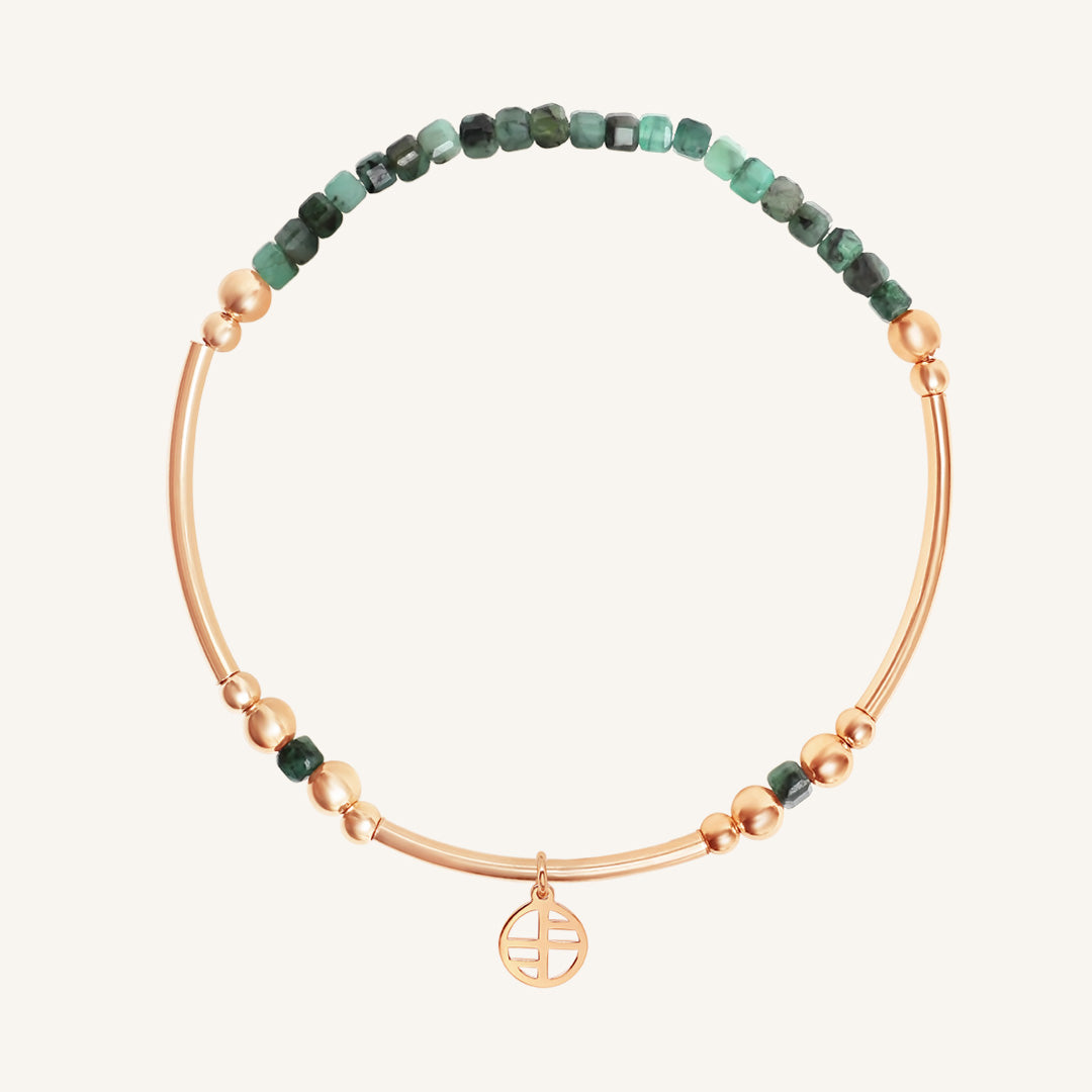 Bracelet with green beads and rose gold accents on a white background