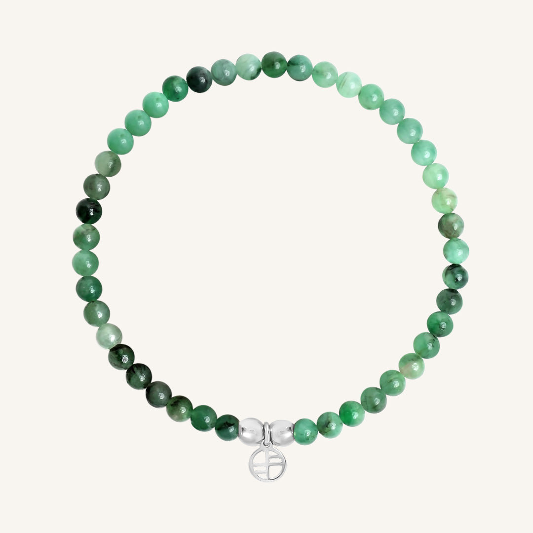 Green beaded bracelet with a silver peace symbol charm on a white background