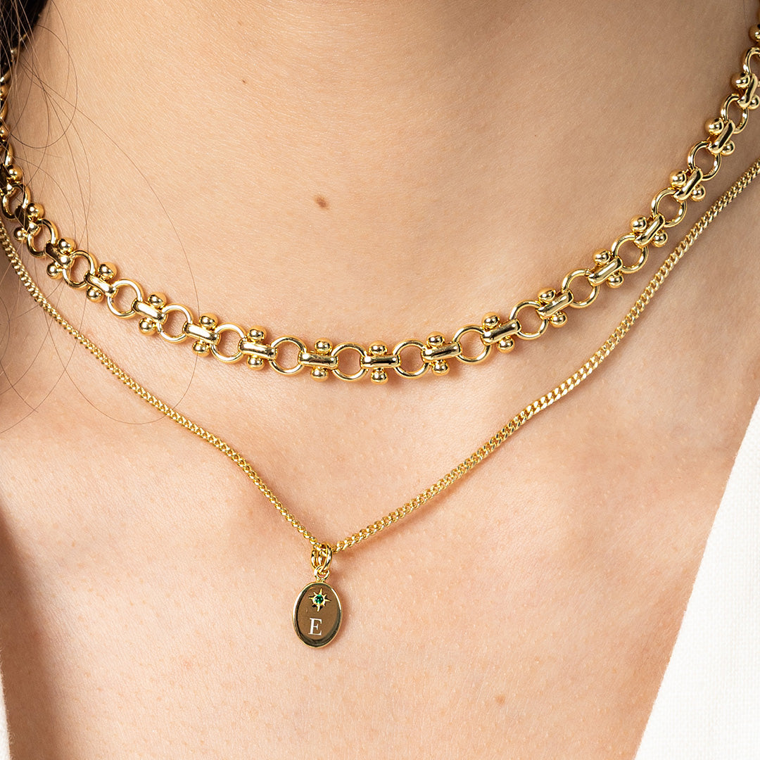 Gold chain necklaces on a person's neck with a close-up view.