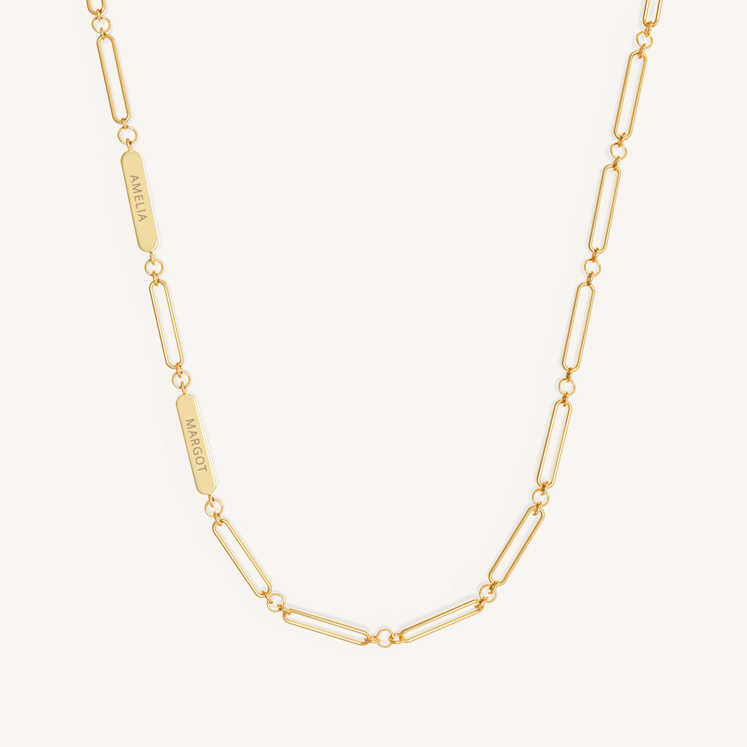 A gold chain necklace with two engraveable panels on a white background