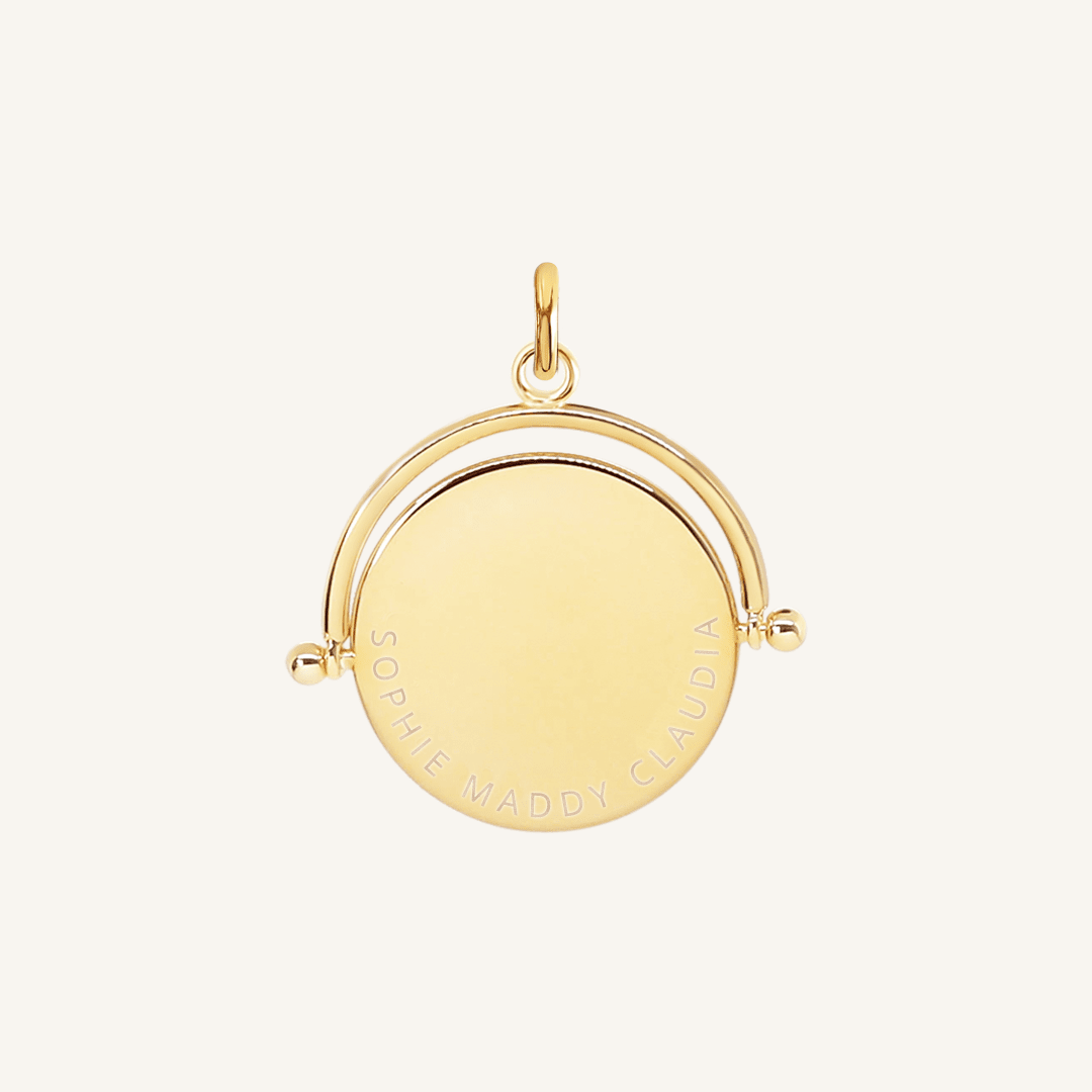 A gold-coloured, engraved pendant with, featuring a spinning mechanism.